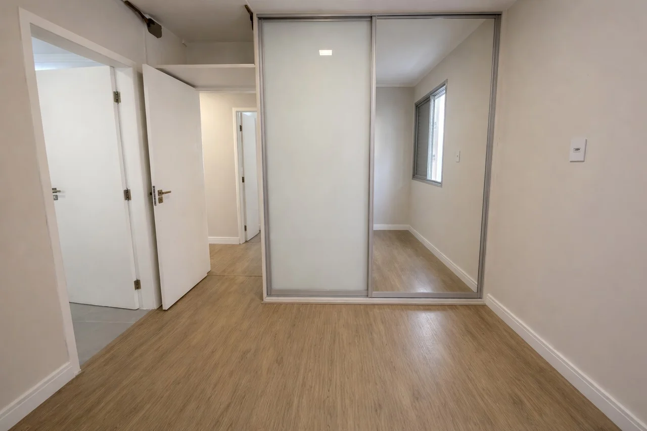 Segundo dormitório com armário embutido de madeira e piso laminado reformado
