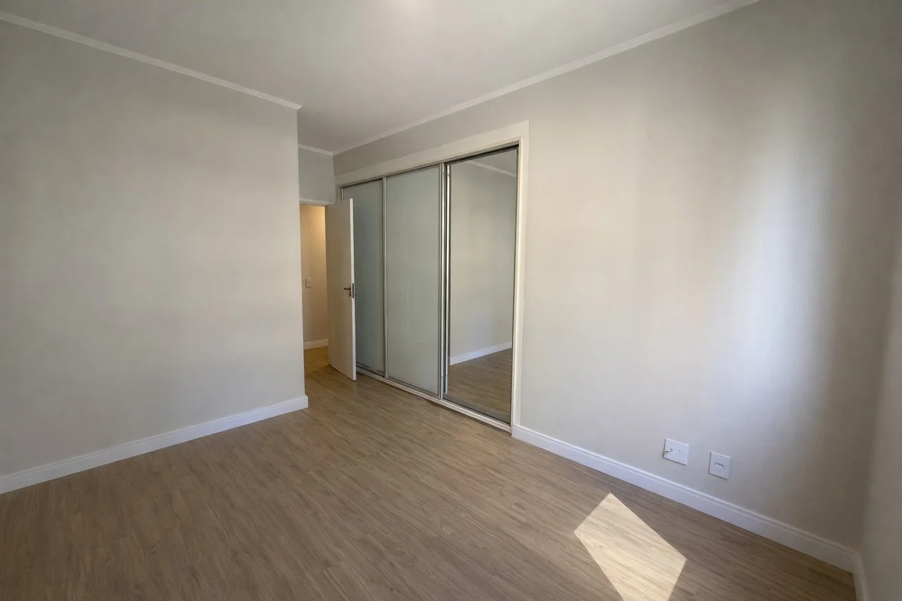 Suíte master com armários embutidos planejados, portas espelhadas e ar condicionado