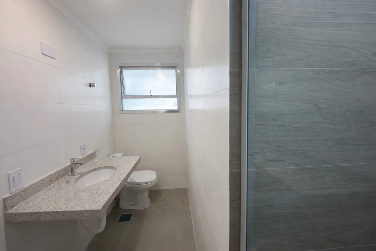 Banheiro da suíte mostrando a pia moderna e acabamentos da reforma elétrica e hidráulica